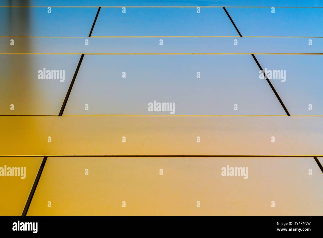 Architecture minimaliste avec panneaux muraux dorés et verre réfléchissant contre un ciel clair Banque D'Images