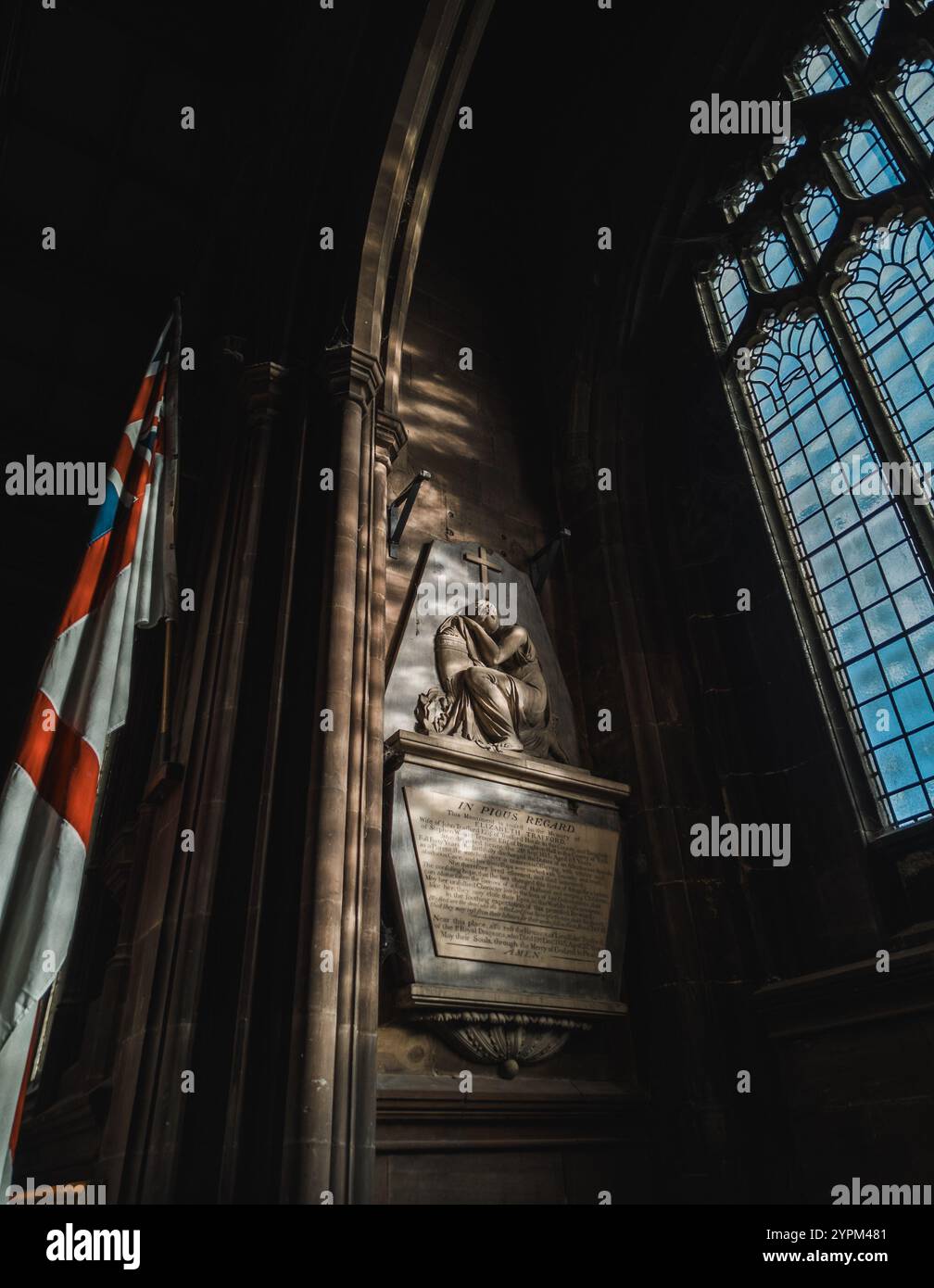 Intérieur serein de l'église avec monument illuminé et vitrail soulignant le patrimoine religieux Banque D'Images