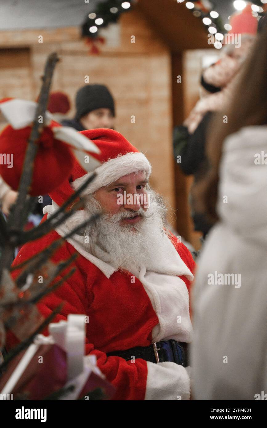 Vieux Père Noël portant chapeau assis au marché de Noël à Sofia, Bulgarie. Banque D'Images