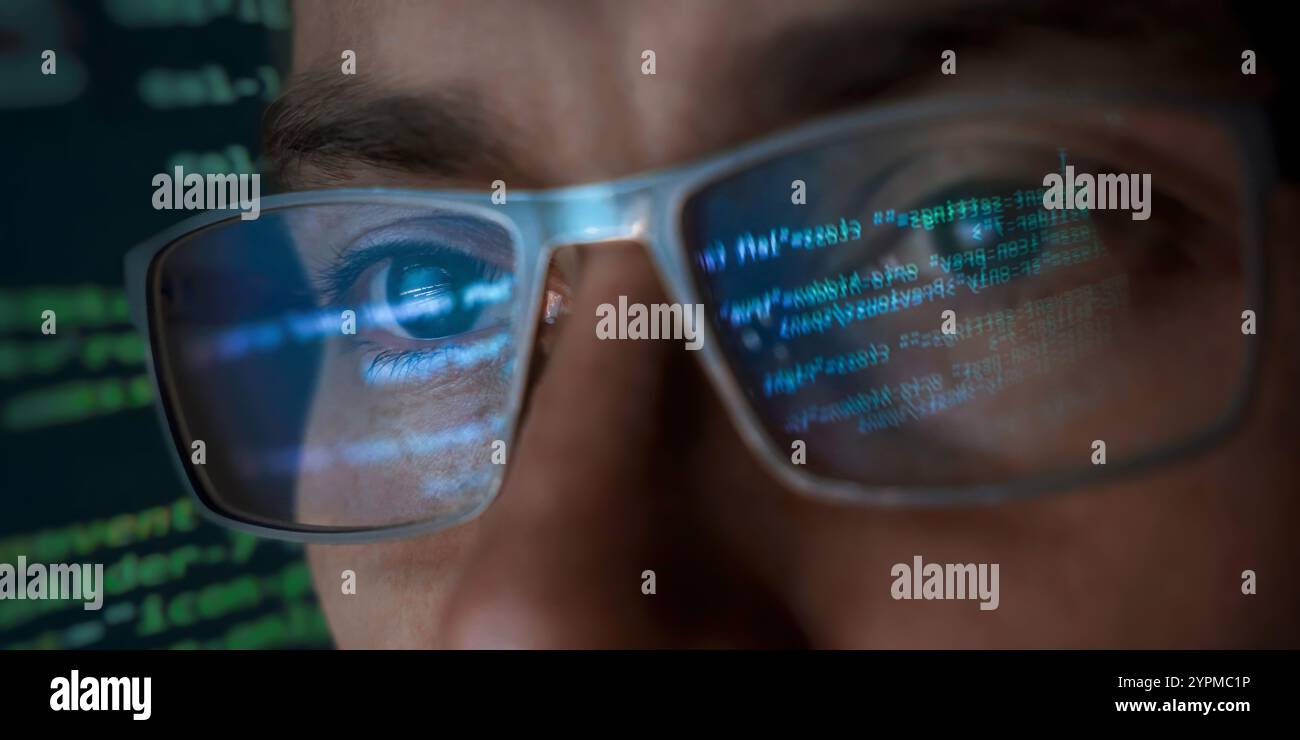 Gros plan du visage d'un programmeur focalisé portant des lunettes qui reflètent des lignes de code de programmation vert et bleu lumineux. Pirate informatique, cybersécurité et IA concept Banque D'Images
