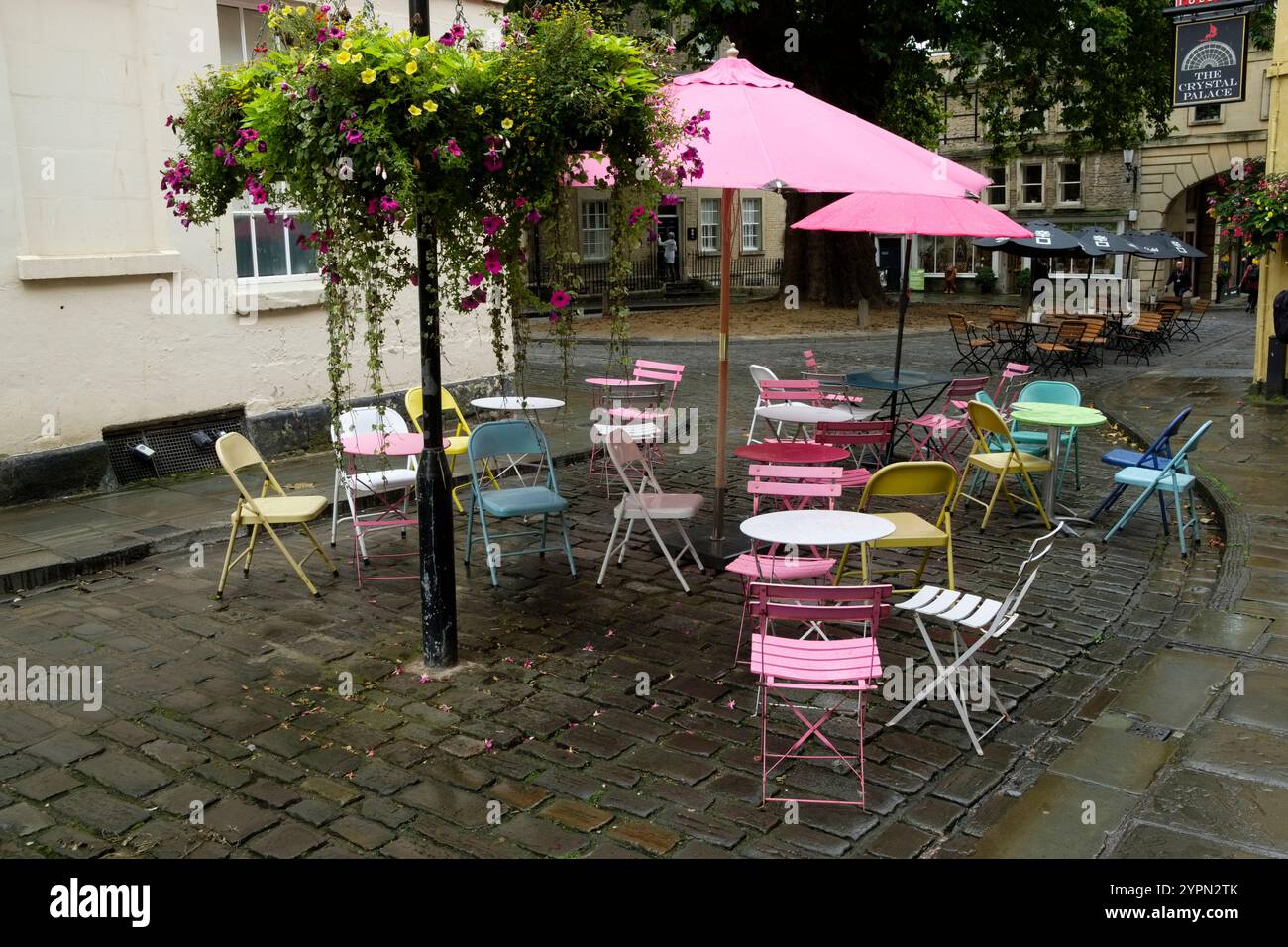 Tables et chaises d'extérieur avec parasols à Abbey Green, bain sous la pluie d'automne, Angleterre. Banque D'Images