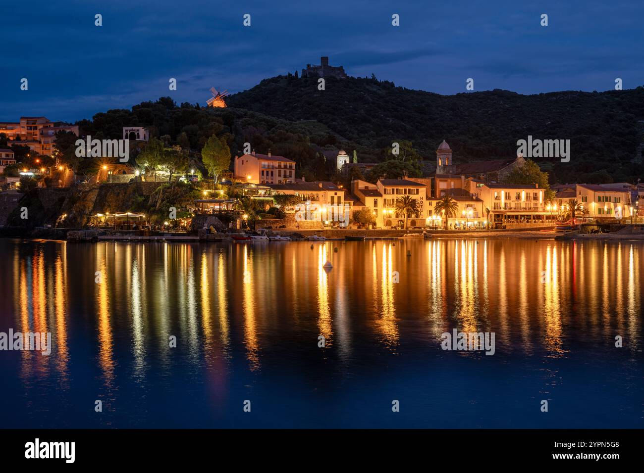 Hôtels illuminés, bars et restaurants sur la promenade de la plage de Collioure en contrebas du Fort Saint-Elme au crépuscule, Languedoc-Roussillion, France Banque D'Images