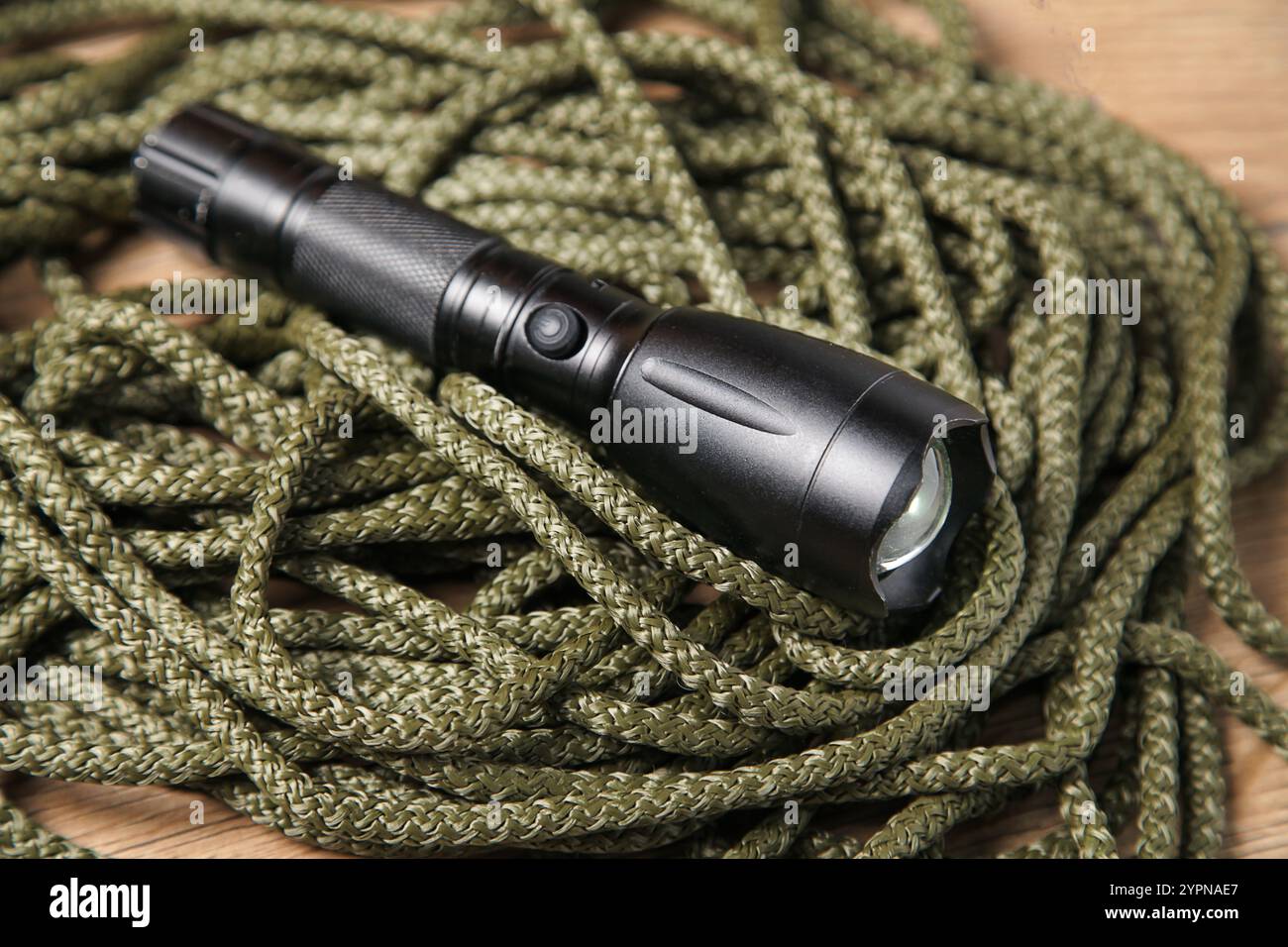 Corde kaki et lampe de poche noire, concept Survival First Aid, outils, équipement de sécurité d'alpinisme. Banque D'Images