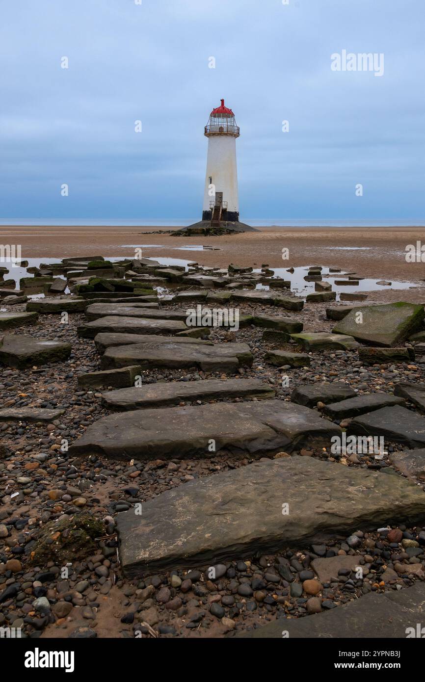Phare de point of Ayr vu à marée basse debout sur Talacre Beach avec des rochers au premier plan, prise le 30 octobre 2024. Banque D'Images