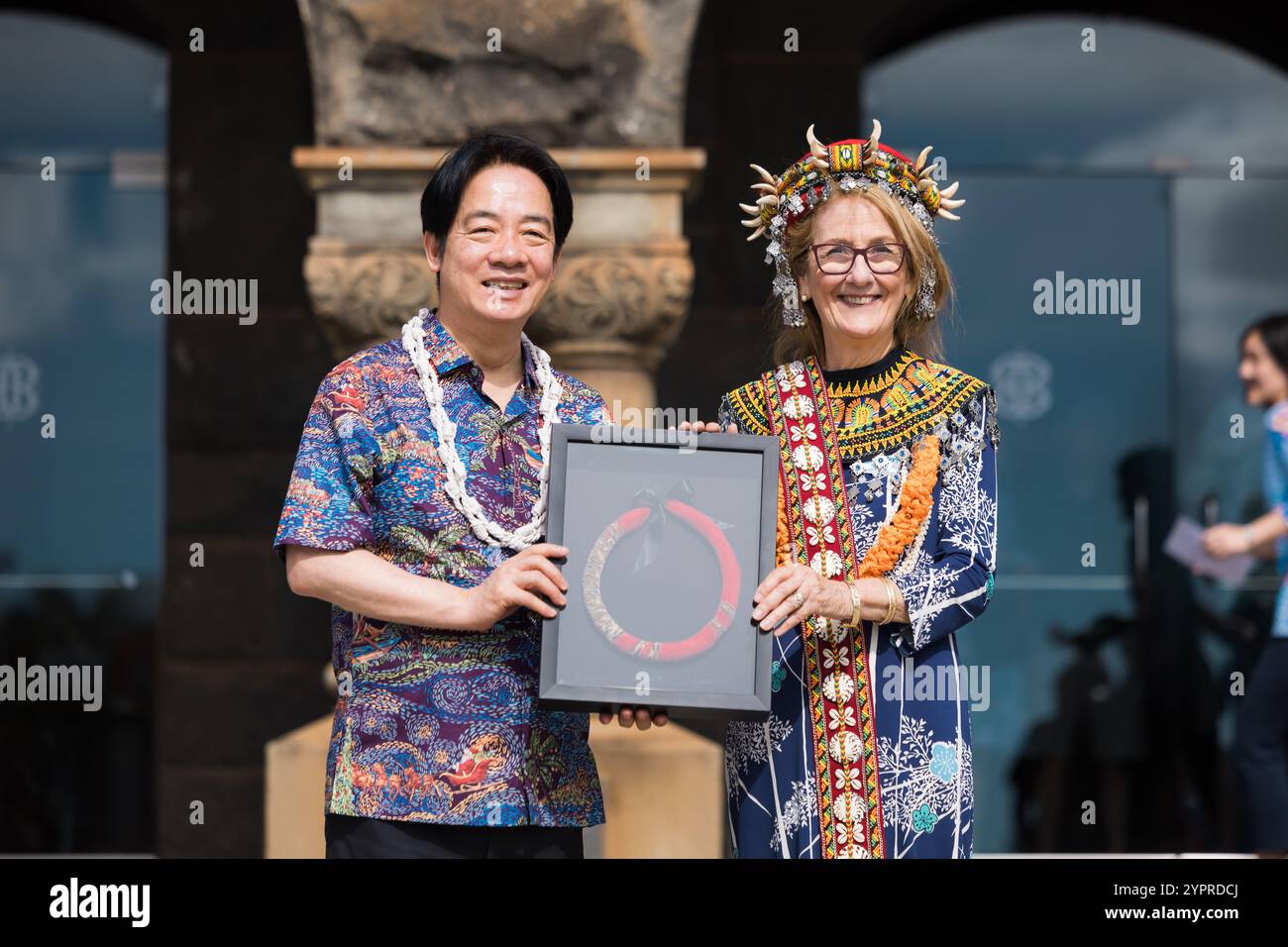Honolulu, États-Unis. 30 novembre 2024. Le président taïwanais Lai Ching-te, à gauche, reçoit un lei hulu rouge encadré, ou guirlande de plumes, réalisé par le maître artiste de plumes Kawika Lum-Nelmida par Dee Jay Mailer, PDG du Bishop Museum, à droite, lors d'une visite au musée, le 30 novembre 2024 à Honolulu, Hawaï. Mailer porte une coiffe, faite par le peuple indigène Paiwan de Taiwan, et des pièces décoratives pour le cou et l'épaule faites par le peuple indigène Atayal, également de Taiwan, qui lui ont été offertes par le président taïwanais. Crédit : Liu Shu Fu/Bureau présidentiel de Taiwan/Alamy Live News Banque D'Images