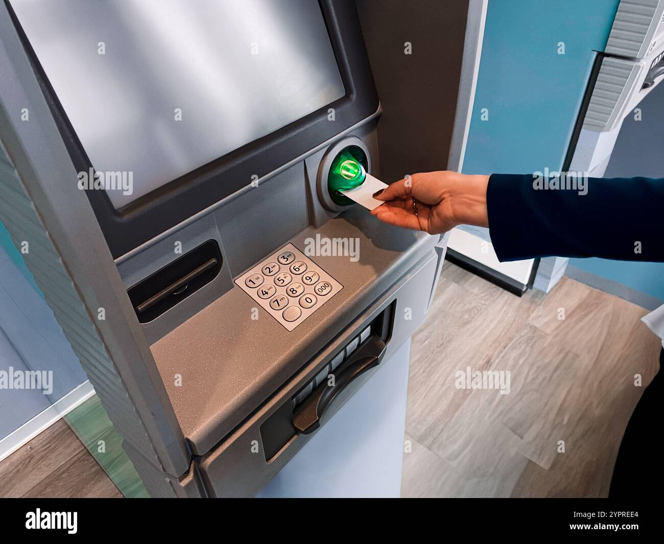 Femme retirant de l'argent au distributeur automatique. Retirer du compte bancaire à l'aide d'une carte de débit. Guichet automatique bancaire sécurisé. Retirez de l'argent du distributeur de billets. Financier Banque D'Images