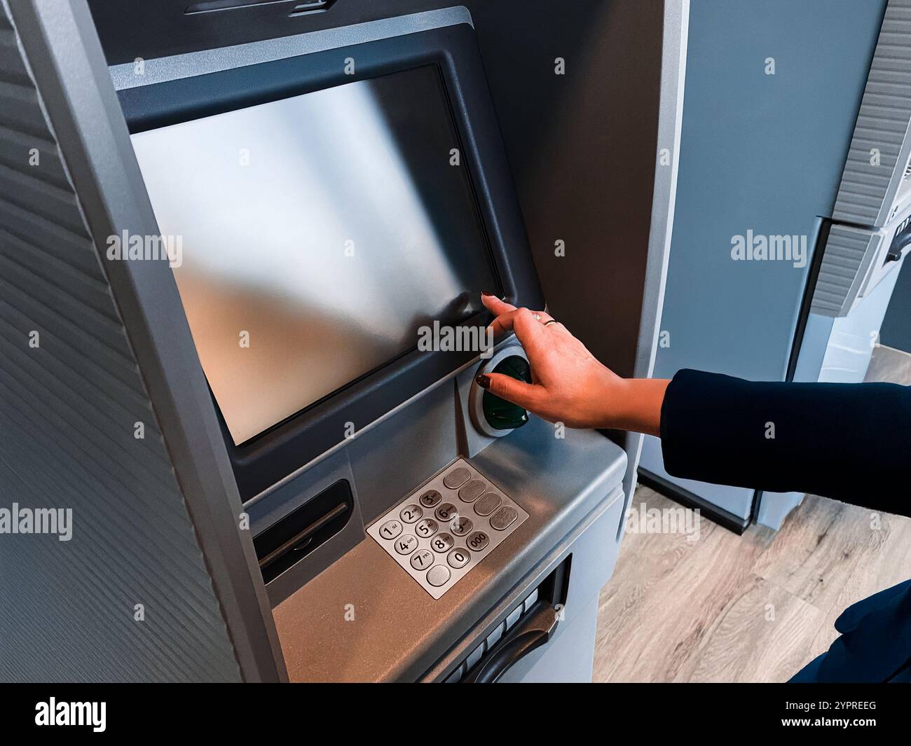 Femme retirant de l'argent au distributeur automatique. Retirer du compte bancaire à l'aide d'une carte de débit. Guichet automatique bancaire sécurisé. Retirez de l'argent du distributeur de billets. Financier Banque D'Images