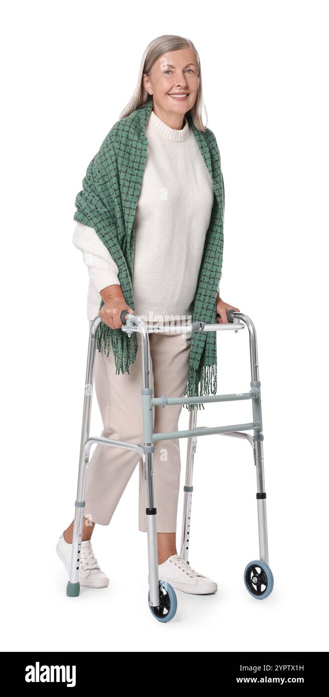 Femme senior utilisant le cadre de marche sur fond blanc Banque D'Images
