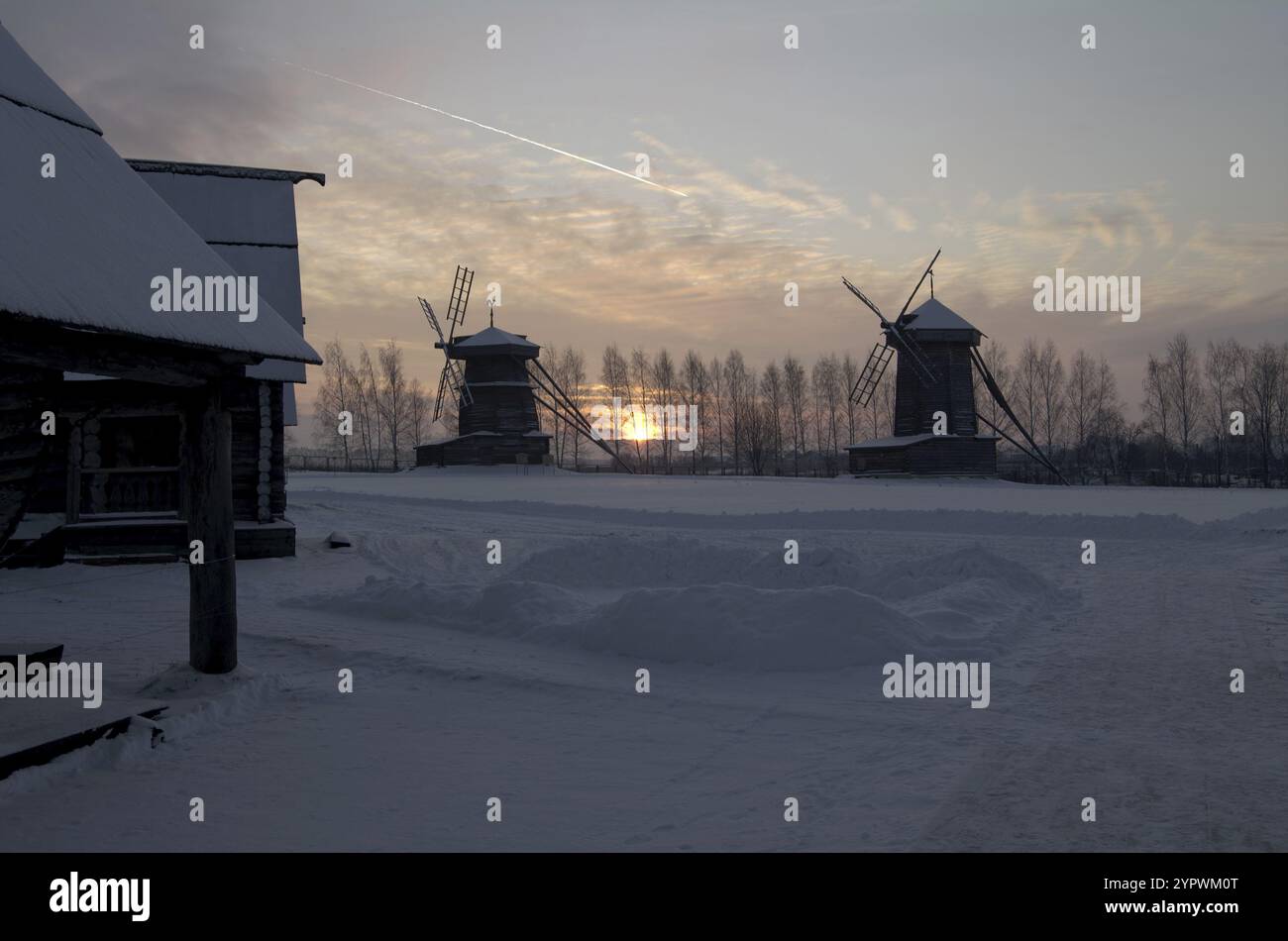 Soirée d'hiver. Le soleil se couche entre deux moulins à vent. Musée d'architecture en bois, Souzdal, Russie, Europe Banque D'Images