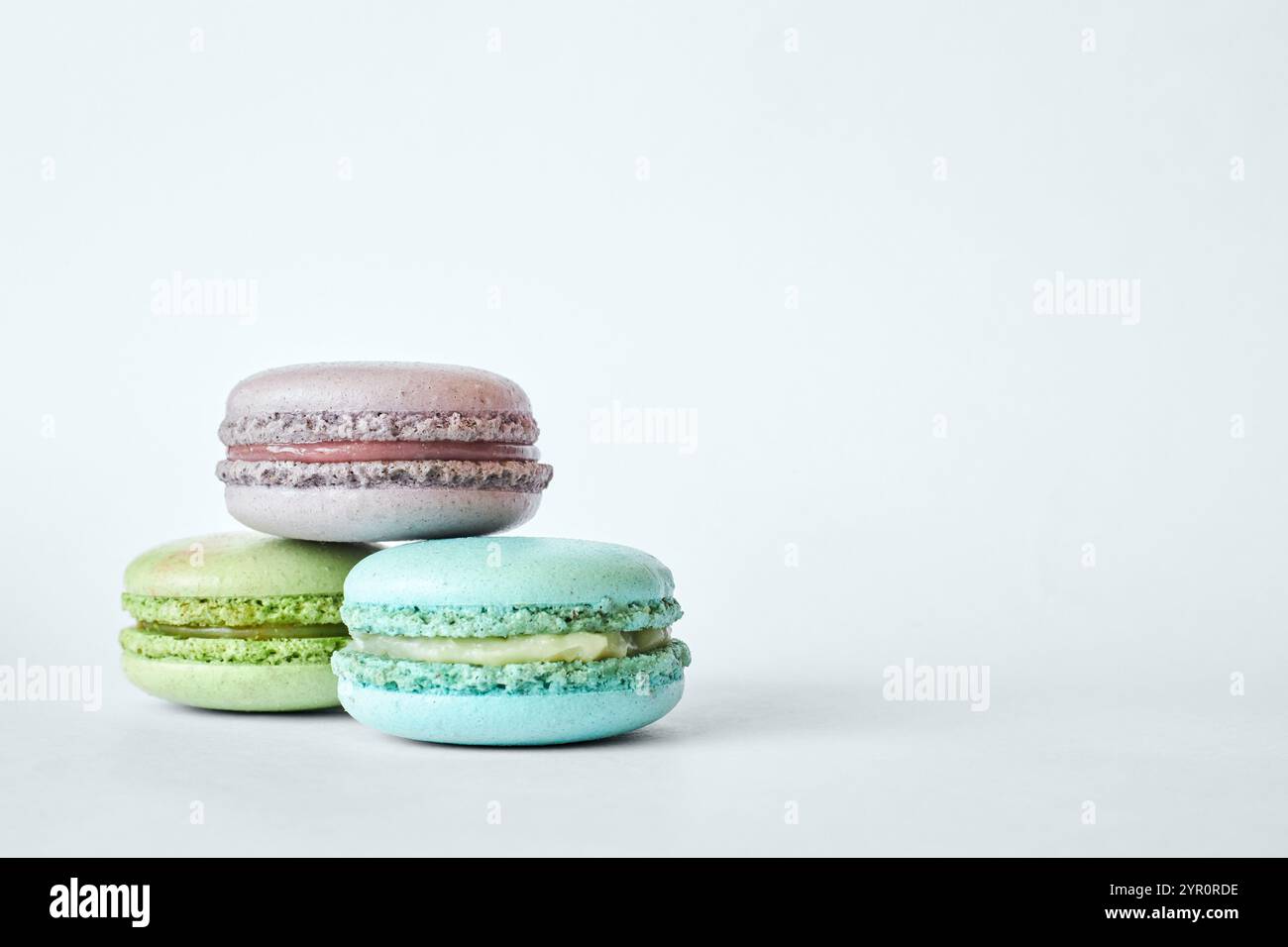 Pile de trois macarons français colorés, gâteaux aux saveurs différentes empilés dans une pyramide, menthe, pomme, saveur de groseille. dessert maison, macarons a Banque D'Images