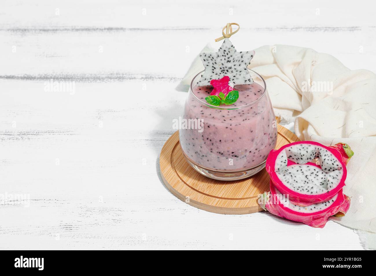 Pitaya smoothie, boisson détox saine. Boisson tendance, idée de petit déjeuner utile. Lumière dure, ombre sombre, fond en bois blanc, espace de copie Banque D'Images
