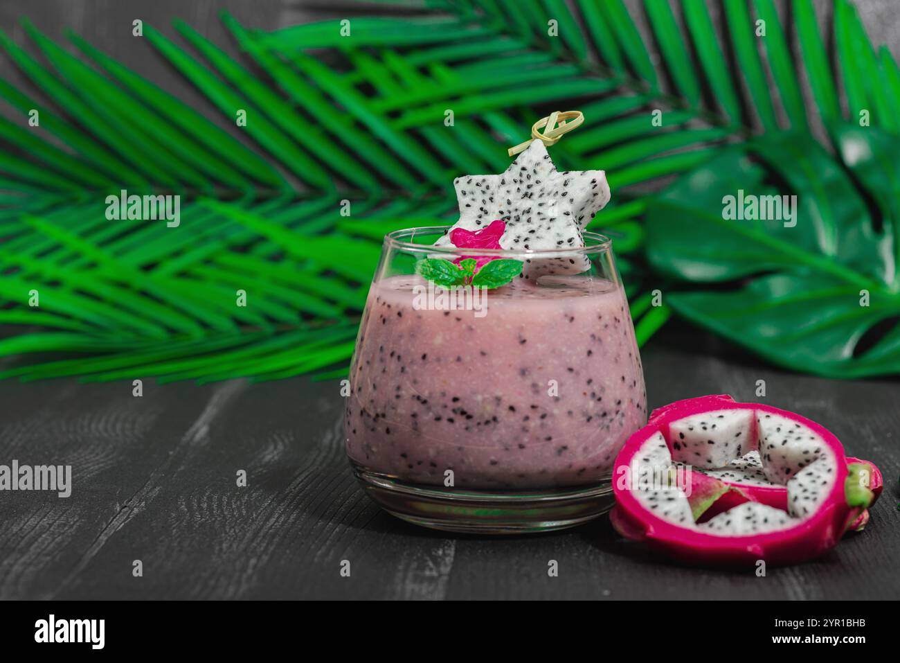 Pitaya smoothie, boisson détox saine. Boisson tendance, idée de petit déjeuner utile. Lumière dure, ombre sombre, fond en bois noir, espace de copie Banque D'Images