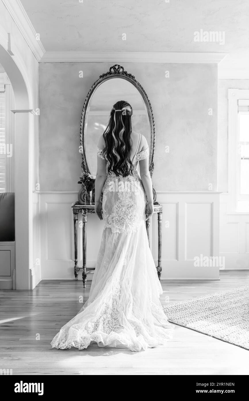 Photo en noir et blanc de mariée regardant dans le miroir Banque D'Images