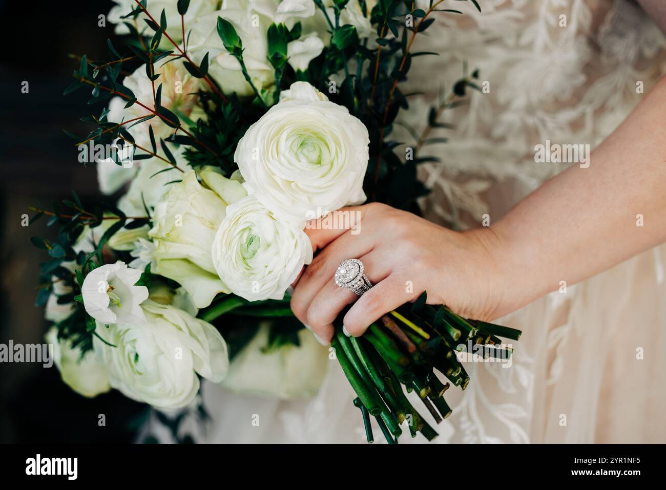 Gros plan de la mariée tenant un bouquet blanc de fleurs de rose Banque D'Images