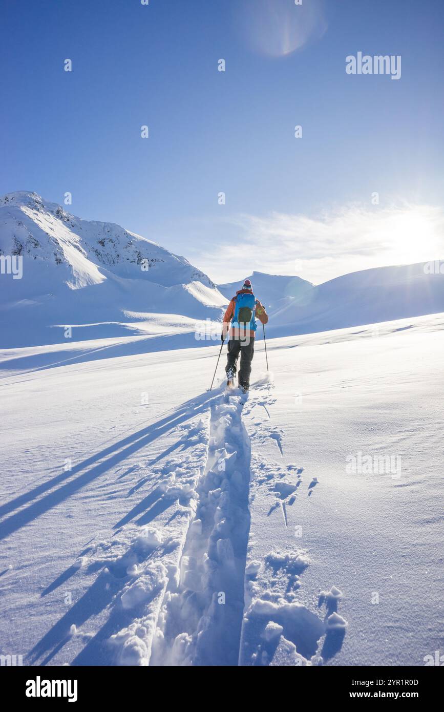 Vue arrière de la personne faisant du ski de randonnée, sentier de rupture avec des pistes fraîches Banque D'Images