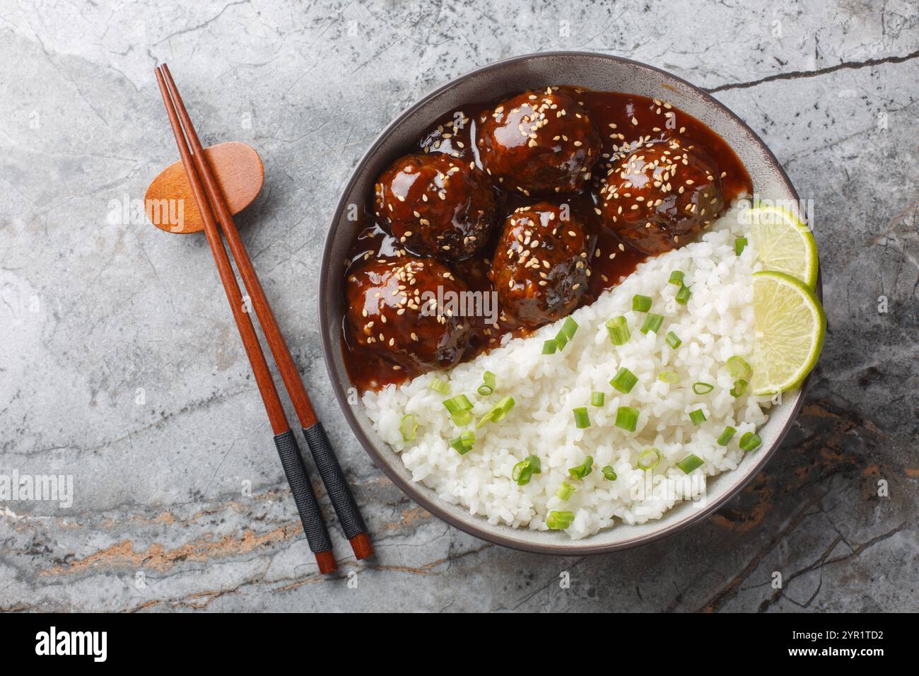 Boulettes de viande glacées à la sauce sriracha au miel servies avec du riz gros plan dans un bol sur une table. vue horizontale de dessus Banque D'Images