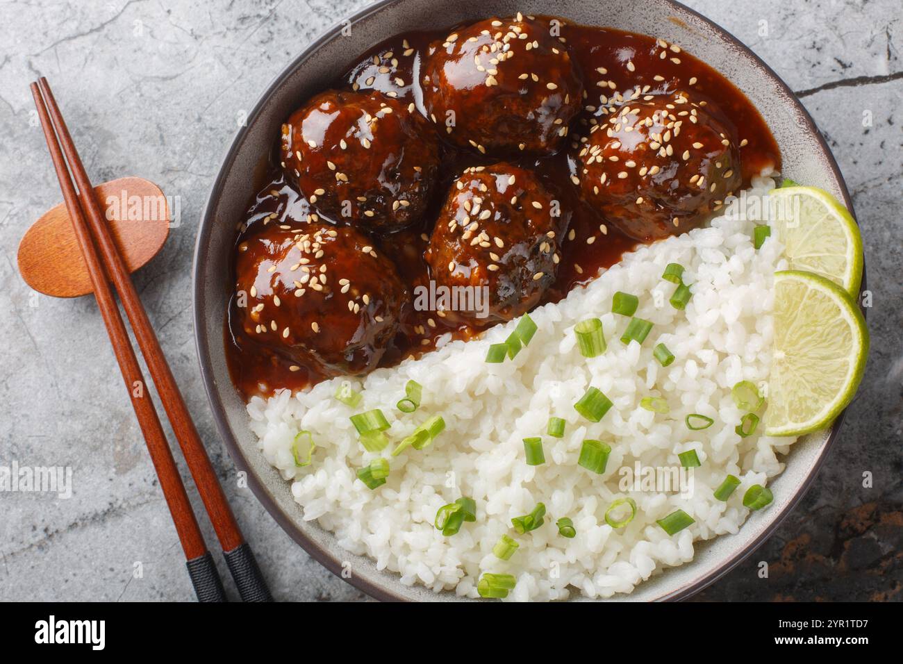 Boule de viande glacée au miel Sriracha servie avec du riz en gros plan sur le bol sur la table. Vue horizontale de dessus Banque D'Images