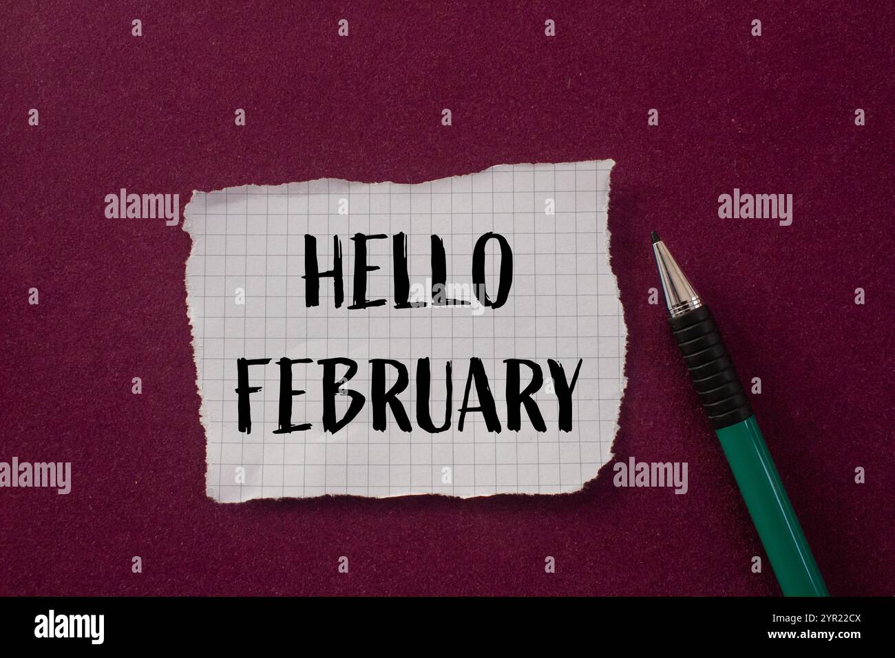 Bonjour février message écrit sur morceau de papier déchiré déchiré avec fond violet. Symbole conceptuel bonjour février. Copier l'espace. Banque D'Images