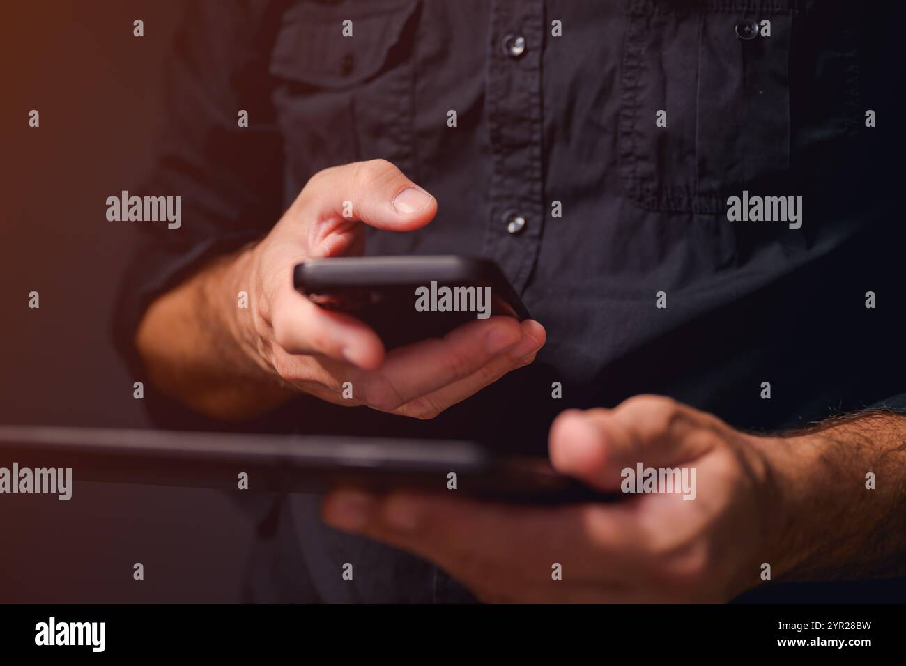 Synchronisation des données, homme utilisant smartphone et tablette numérique pour synchroniser les données, mise au point sélective Banque D'Images