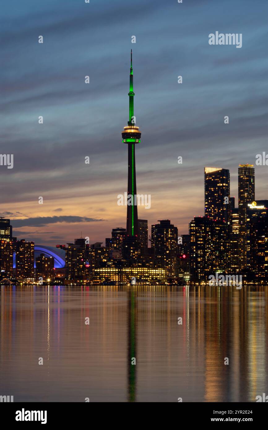 Les gratte-ciel du centre-ville de Toronto alors que le soleil se couche et que les lumières de la ville commencent à scintiller. Vue depuis les îles de Toronto, Ontario Canada Banque D'Images