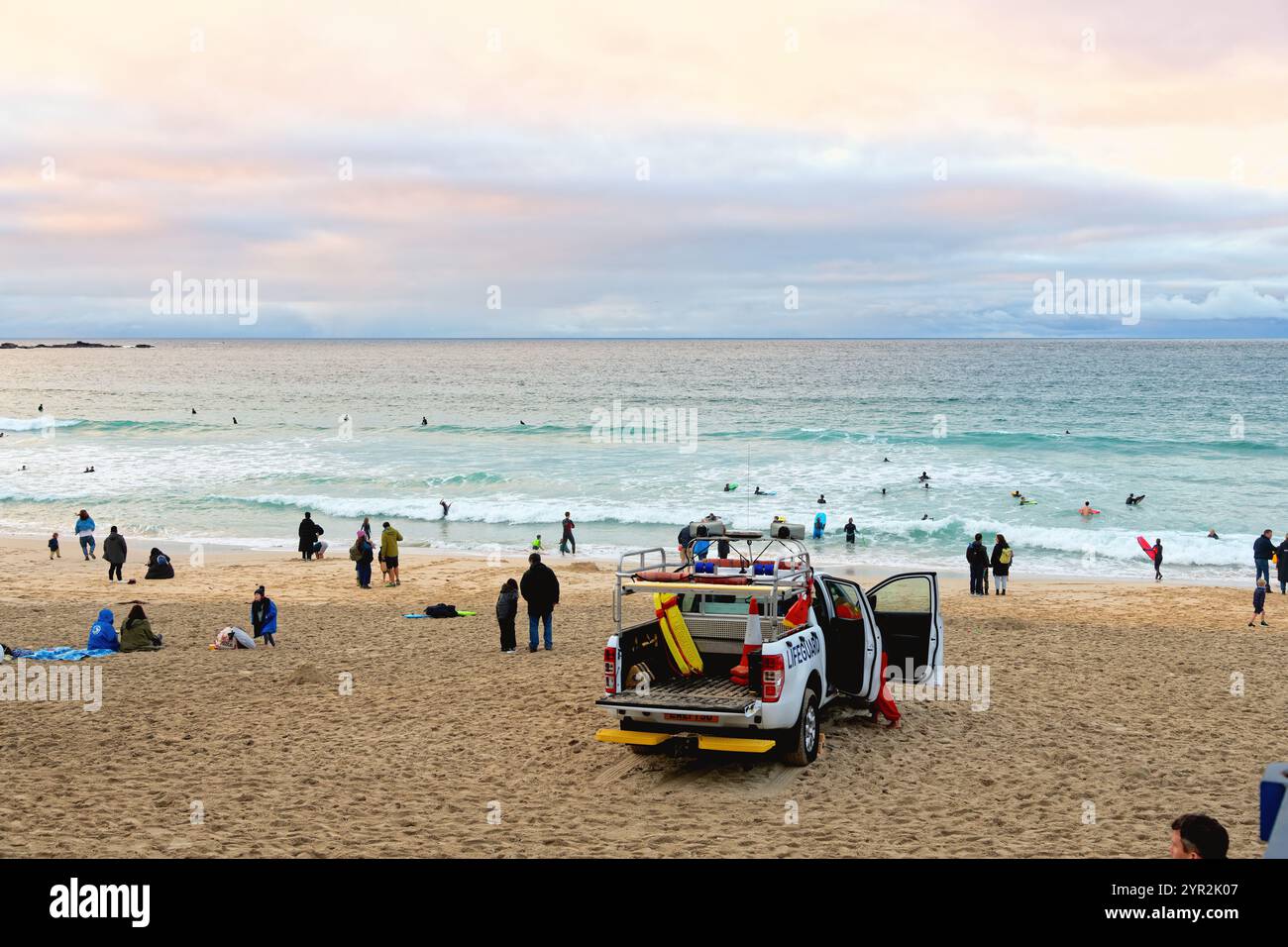 Porthmeor plage au crépuscule un jour d'automne avec quelques surfeurs robustes dans la mer St Ives Cornwall Angleterre Banque D'Images