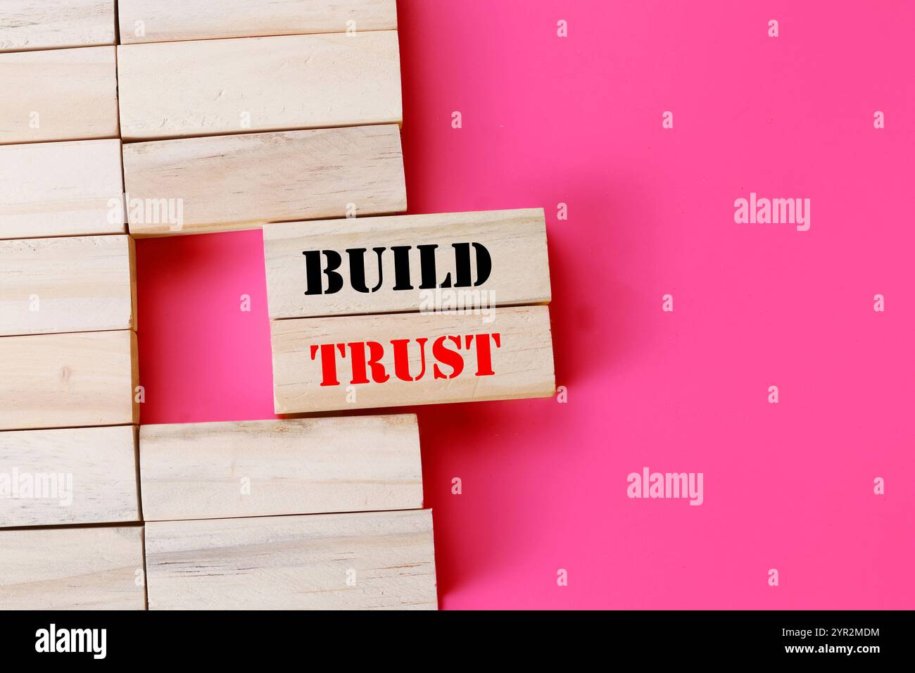 Créer un symbole de confiance. Des blocs de bois avec des mots renforcent la confiance. Beau fond rose. Business et construire le concept de confiance. Copier l'espace. Banque D'Images