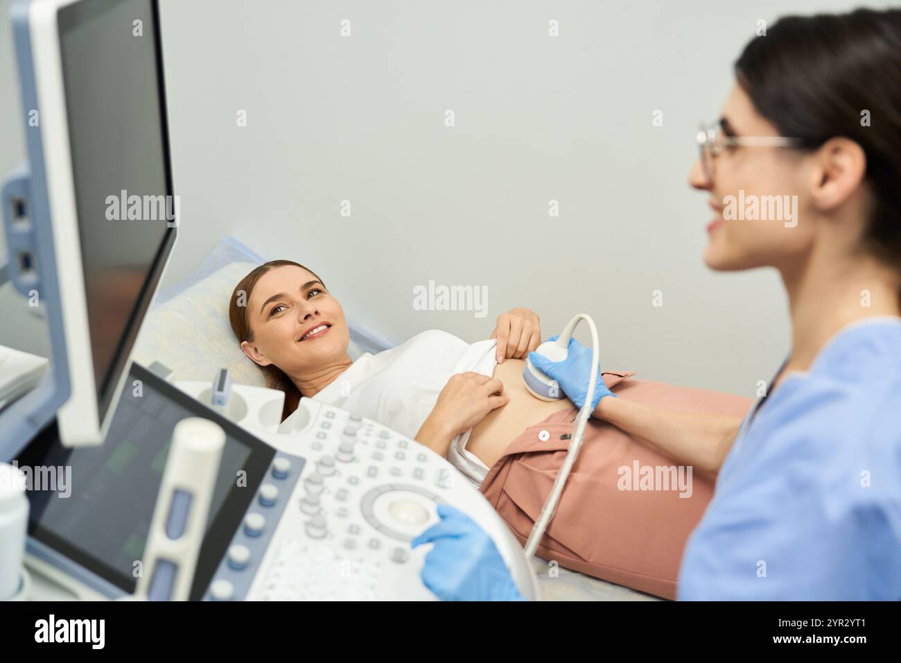 Un gynécologue effectue un examen échographique sur une patiente dans une clinique moderne. Banque D'Images