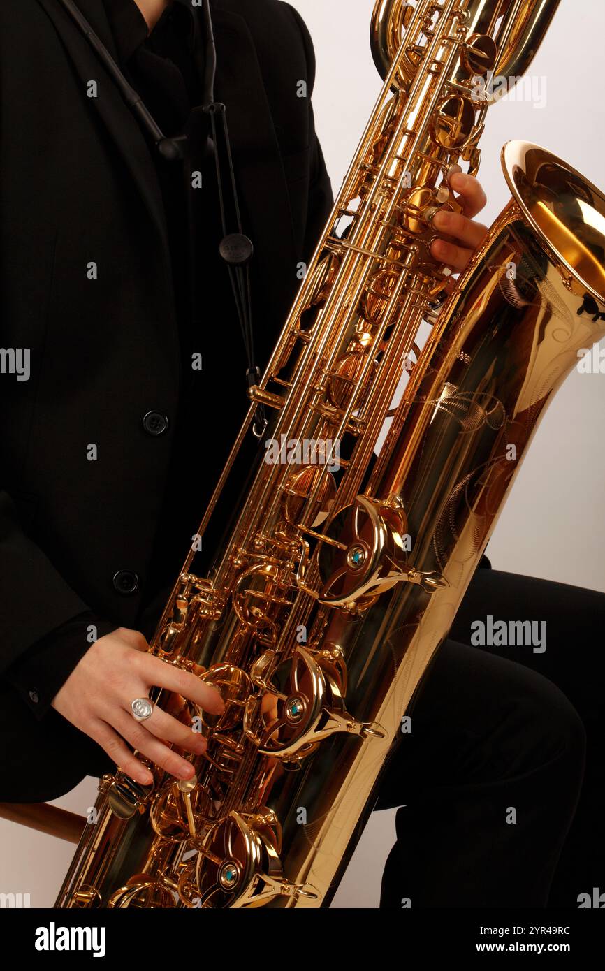 Musicien tenant ou jouant un saxophone baryton. Banque D'Images