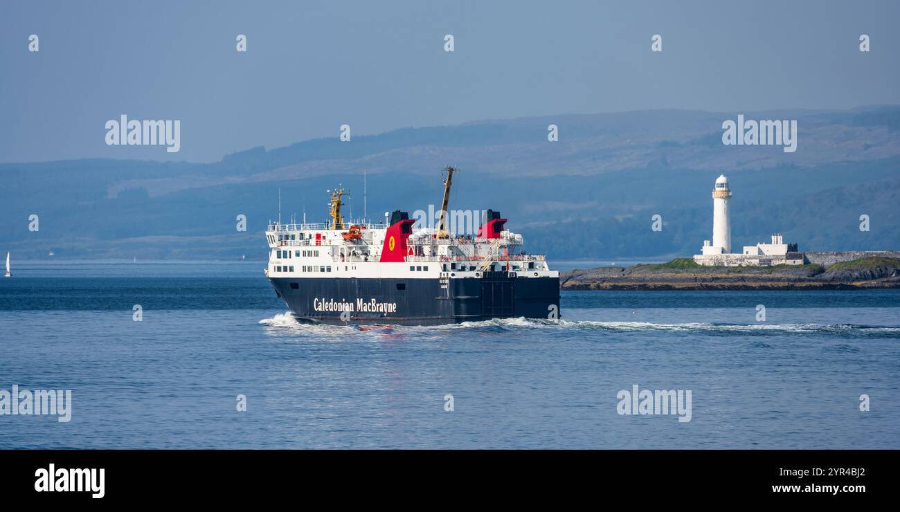 Le ferry CalMac MV Isle of Lewes passe devant le phare de Lismore sur la route d'Oban à Castlebay sur l'île de Barra, à Argyll et Bute, en Écosse, au Royaume-Uni Banque D'Images