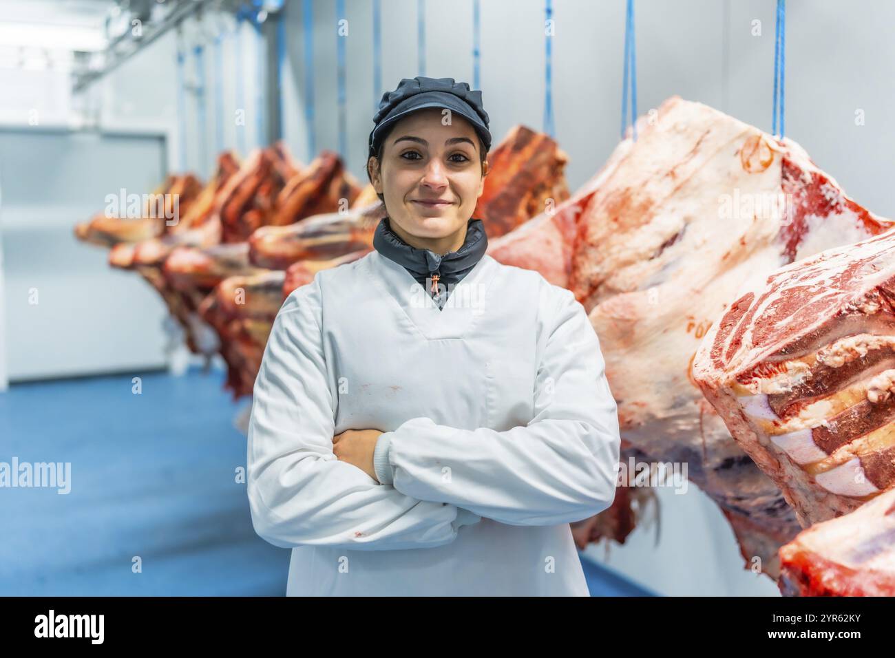 Portrait d'une travailleuse debout fièrement dans la chambre froide d'une usine de viande Banque D'Images