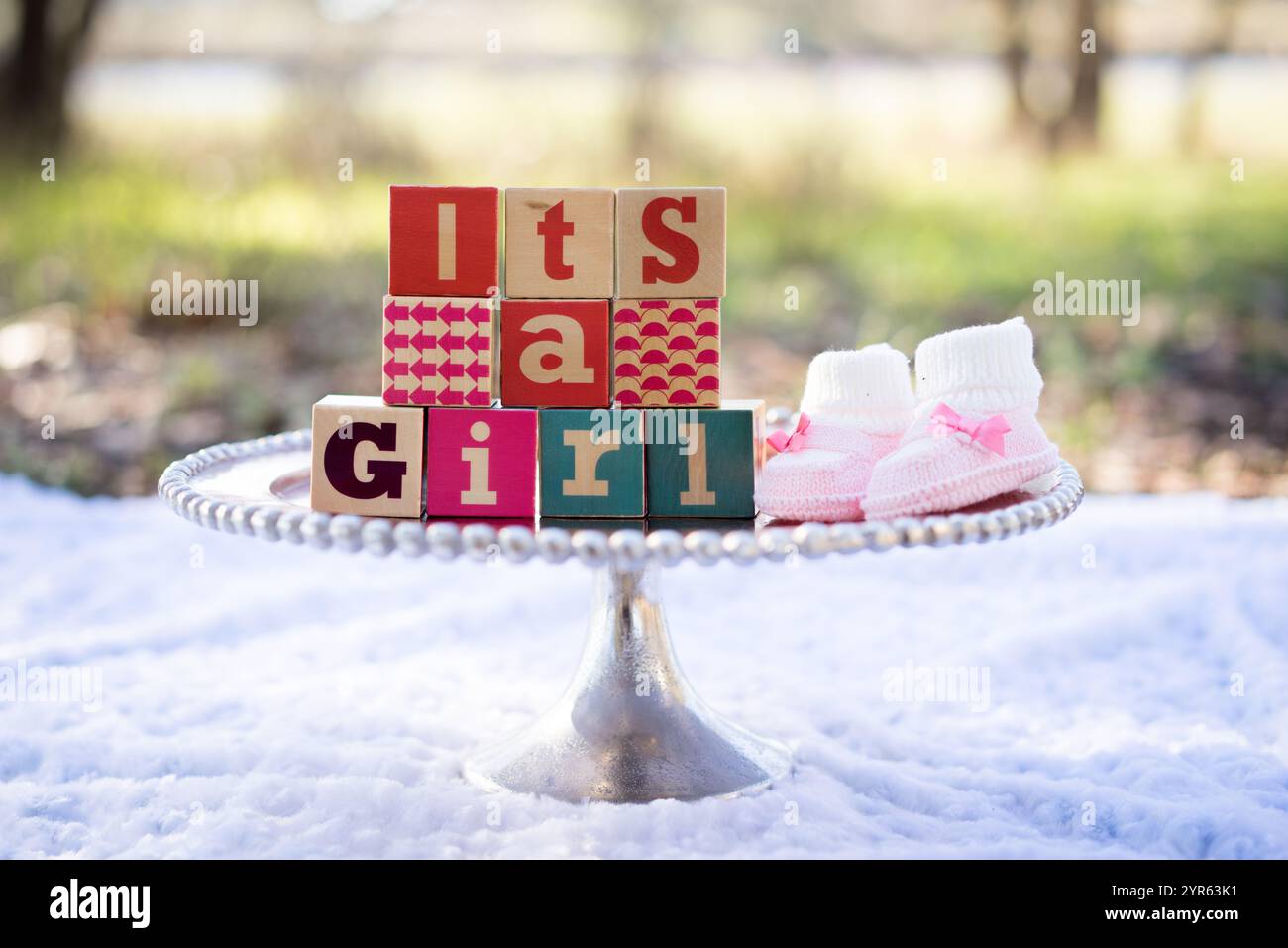 C'est une annonce de fille avec Baby Blocks et Booties à l'extérieur Banque D'Images