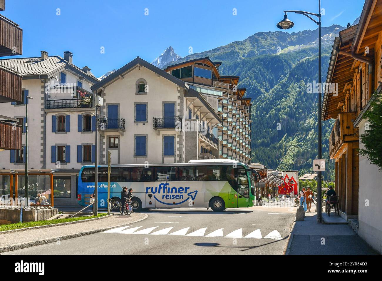 Vue sur le centre de la ville de montagne au pied du massif du Mont Blanc, avec un bus touristique et les aiguilles du Dru en été, Chamonix, France Banque D'Images