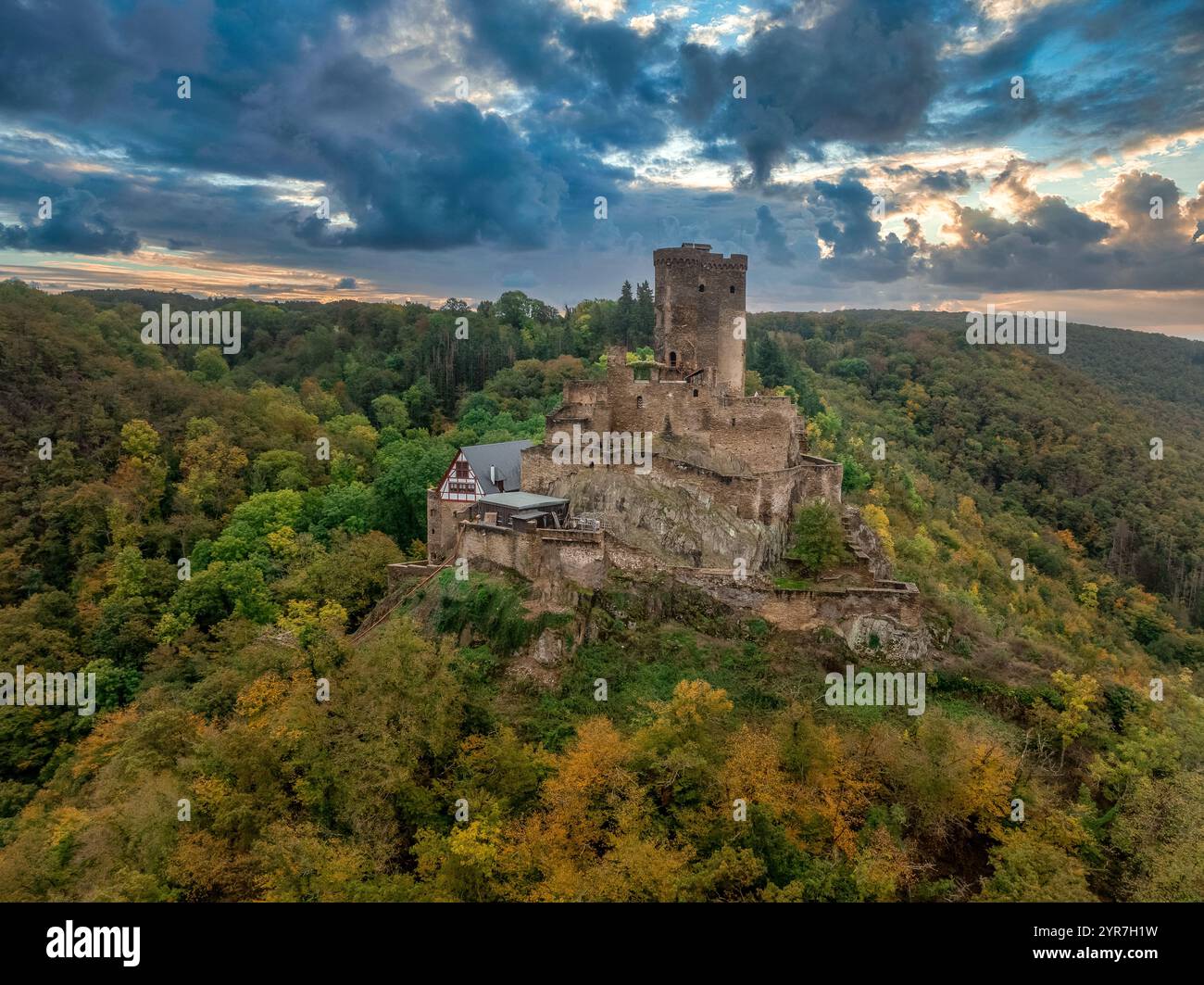 Vue aérienne du château éperon médiéval d'Ehrenburg avec feuillage d'automne en Allemagne près de la rivière Moselle, coucher de soleil spectaculaire avec ciel coloré, grand donjon, baile Banque D'Images