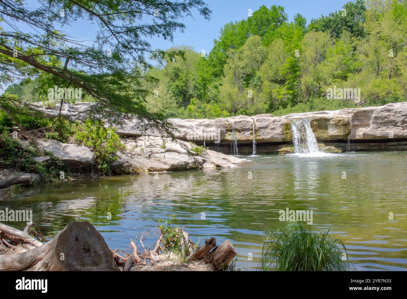 Vue panoramique d'une petite cascade seule les rochers entourés d'arbres et de végétation. Photo prise au McKinney Falls State Park à Austin, Texas Banque D'Images