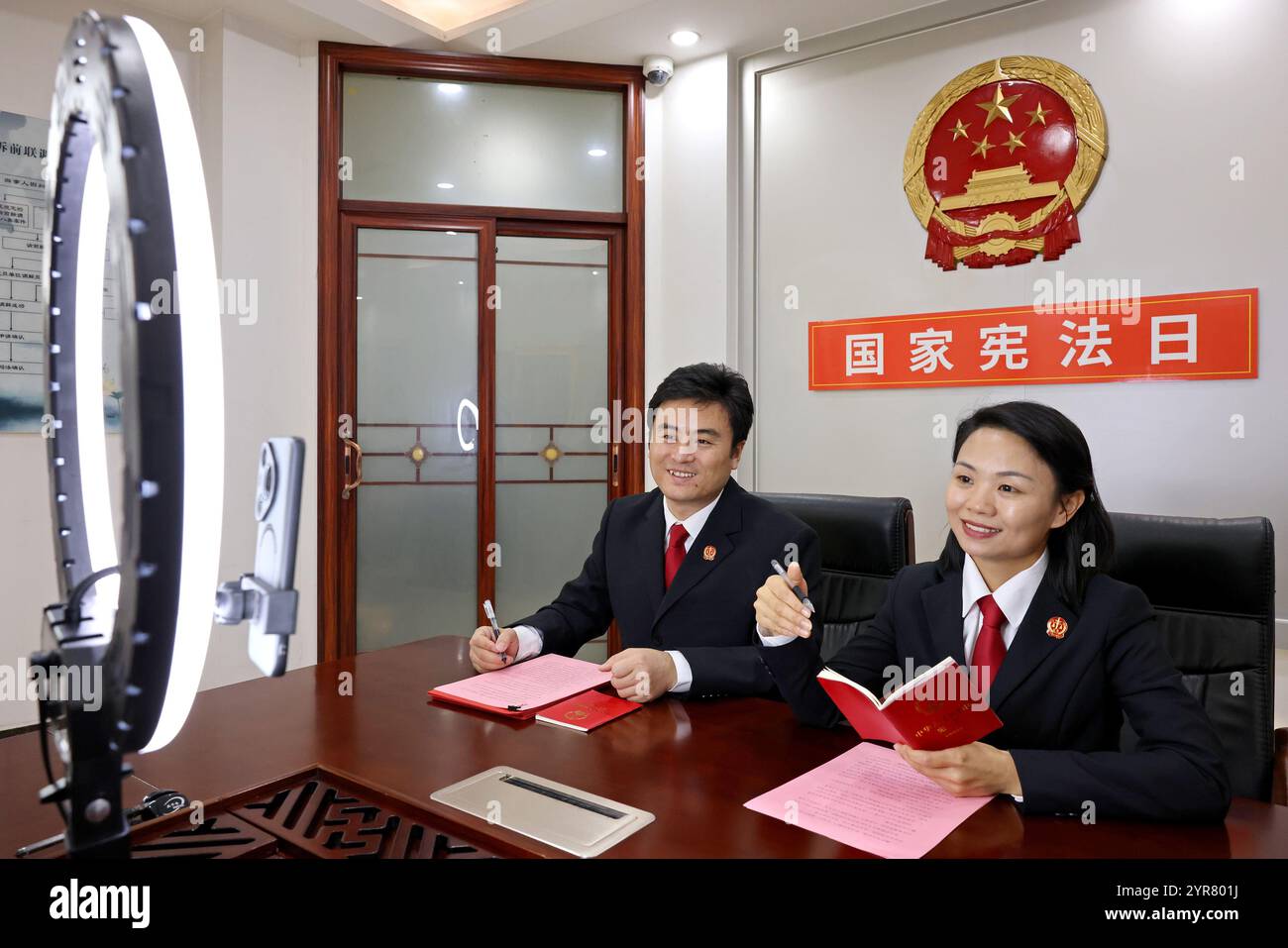 ZAOZHUANG, CHINE - 3 DÉCEMBRE 2024 - deux juges font la promotion de la connaissance constitutionnelle auprès des téléspectateurs lors d'une émission en direct au Shizhong District People's Banque D'Images