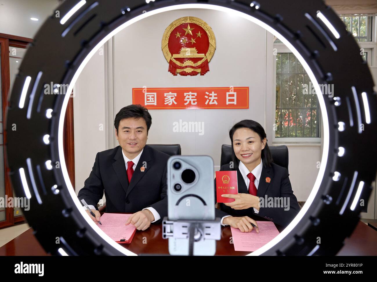 ZAOZHUANG, CHINE - 3 DÉCEMBRE 2024 - deux juges font la promotion de la connaissance constitutionnelle auprès des téléspectateurs lors d'une émission en direct au Shizhong District People's Banque D'Images