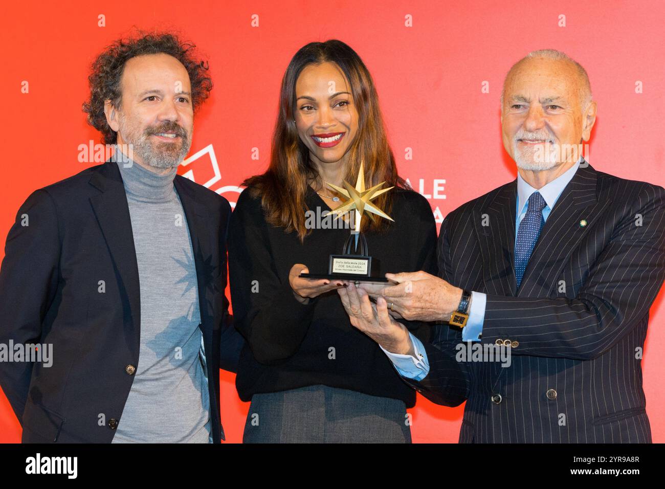 Turin, Italie. 3 décembre 2024. L'actrice Zoe Saldana reçoit le prix 'Stella della mole' au Musée National Italien du Cinéma de Turin (Italie). Sur la photo Zoé Saldana (au centre) avec Enzo Ghigo (à droite) et Carlo Chatrian (à gauche) crédit : Marco Destefanis/Alamy Live News Banque D'Images