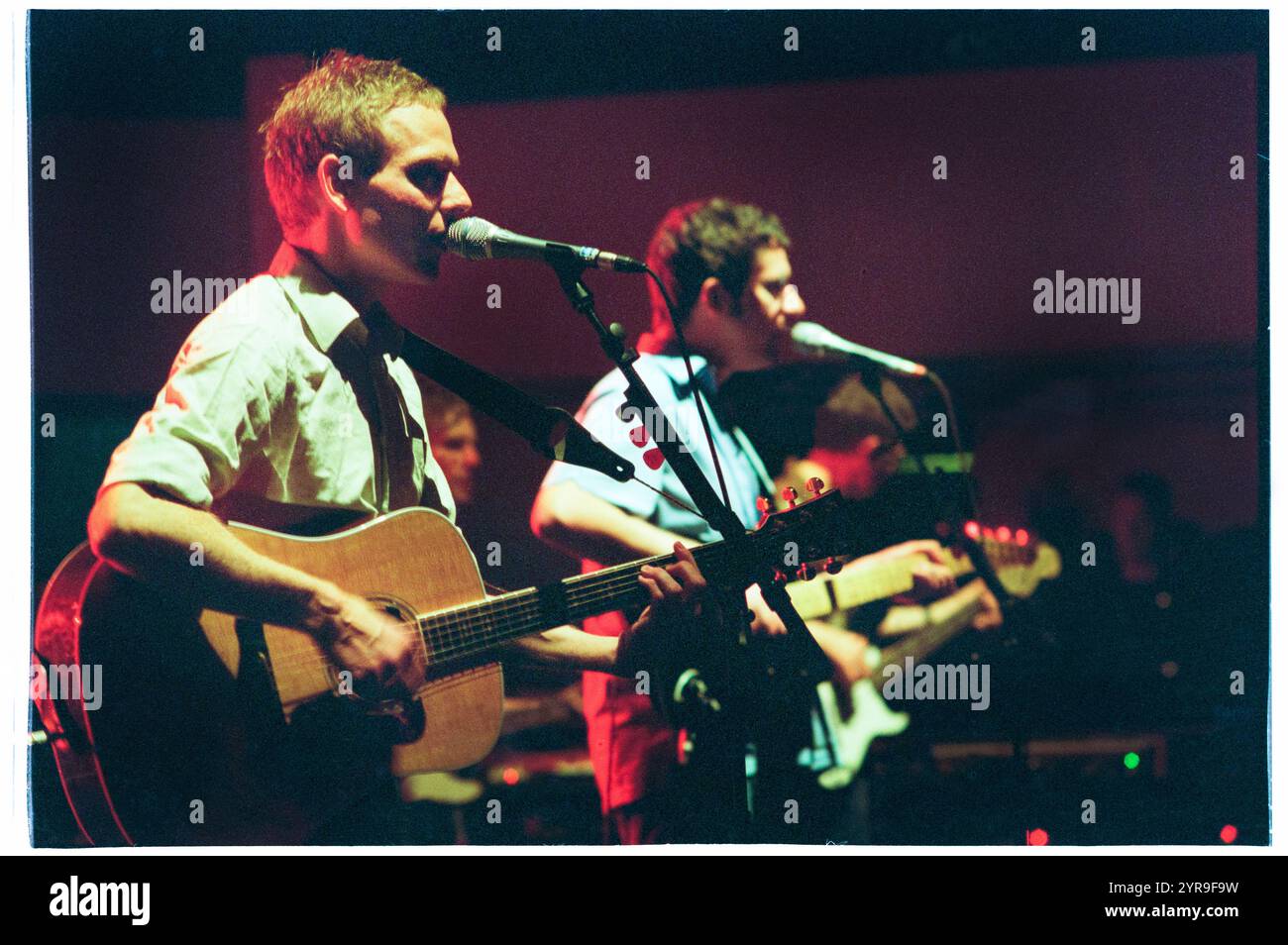 STUART MURDOCH, BELLE & SEBASTIAN, CONCERT, 2001 : Stuart Murdoch chanteur principal et auteur-compositeur de belle & Sebastian jouant en concert au St David's Hall à Cardiff, pays de Galles, Royaume-Uni le 1er juillet 2001. Photographie : ROB WATKINS. INFO : belle and Sebastian est un groupe indie pop écossais formé en 1996, connu pour ses paroles littéraires et son mélodique inspiré du folk. Dirigés par Stuart Murdoch, ils ont été salués avec des albums comme If You're Feeling Sinister, mêlant introspection et narration fantaisiste. Banque D'Images