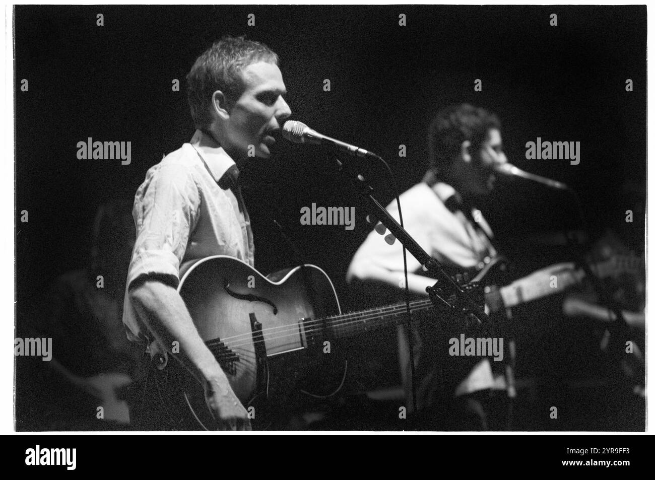 STUART MURDOCH, BELLE & SEBASTIAN, CONCERT, 2001 : Stuart Murdoch chanteur principal et auteur-compositeur de belle & Sebastian jouant en concert au St David's Hall à Cardiff, pays de Galles, Royaume-Uni le 1er juillet 2001. Photographie : ROB WATKINS. INFO : belle and Sebastian est un groupe indie pop écossais formé en 1996, connu pour ses paroles littéraires et son mélodique inspiré du folk. Dirigés par Stuart Murdoch, ils ont été salués avec des albums comme If You're Feeling Sinister, mêlant introspection et narration fantaisiste. Banque D'Images