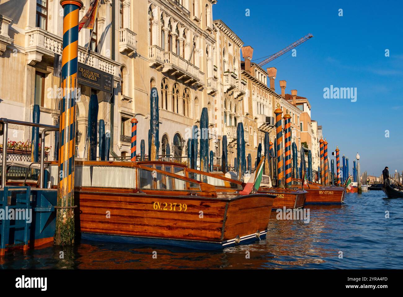 Bateaux-taxis classiques en bois amarrés devant des hôtels de luxe sur le Grand canal, Venise, Italie. Banque D'Images
