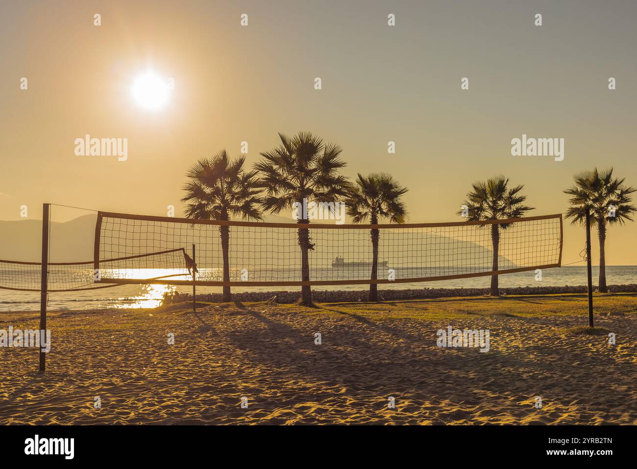 Filet de volley-ball sur la plage tropicale avec des palmiers au coucher du soleil. Beach volley tropical. Personne, Copier l'espace. Banque D'Images