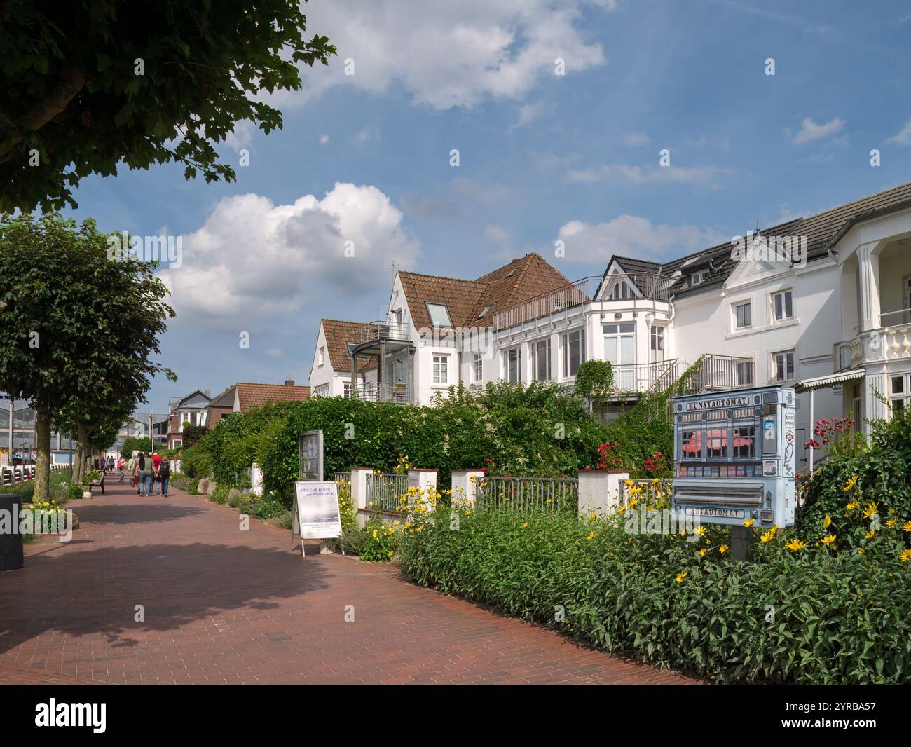 Les gens marchent sur la promenade Strandstrasse et les maisons blanches mitoyennes à Laboe, Schleswig-Holstein, Allemagne Banque D'Images