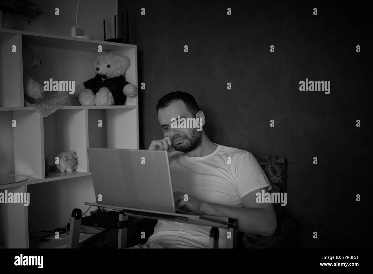 un homme de 30 ans est stressé lorsqu'il travaille sur un ordinateur portable depuis son bureau à domicile Banque D'Images