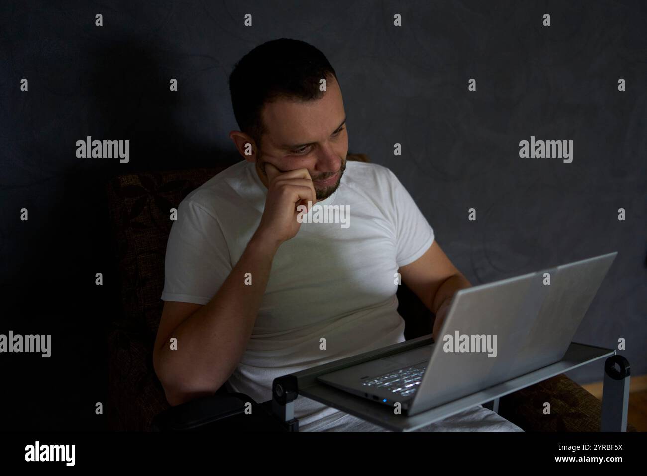 un homme de 30 ans est stressé lorsqu'il travaille sur un ordinateur portable depuis son bureau à domicile Banque D'Images