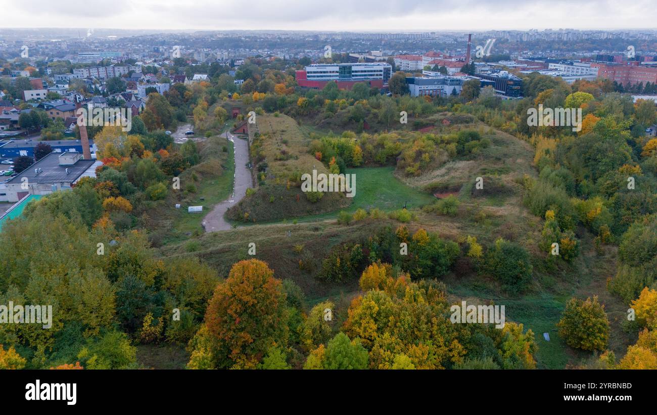 Vue aérienne d'une ancienne fortification entourée de feuillage d'automne, avec une longue structure en briques avec des portes voûtées et des toits herbeux. Le Landscap Banque D'Images