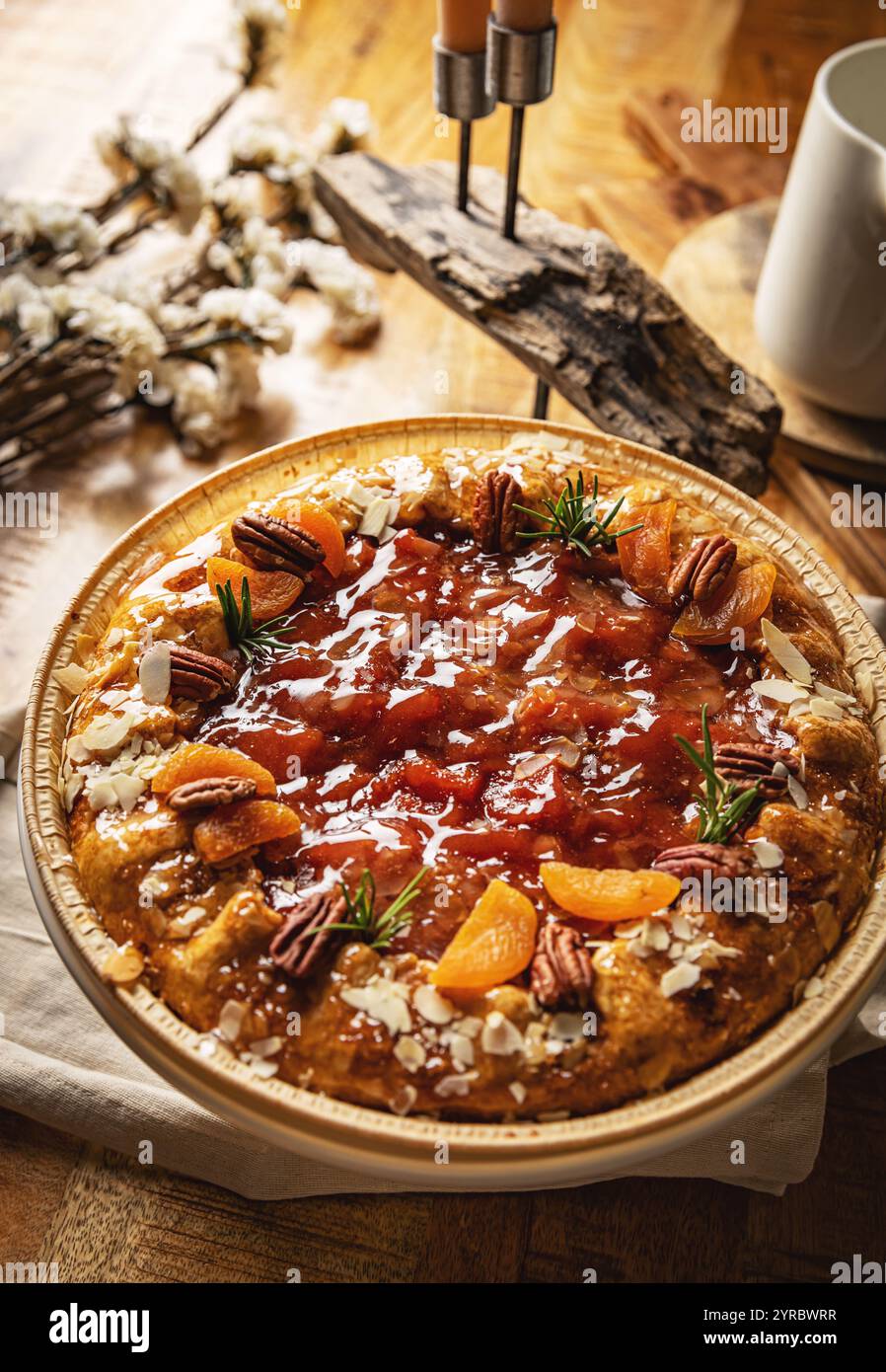 Délicieuse tarte aux abricots et aux noix de pécan au romarin sur table rustique Banque D'Images