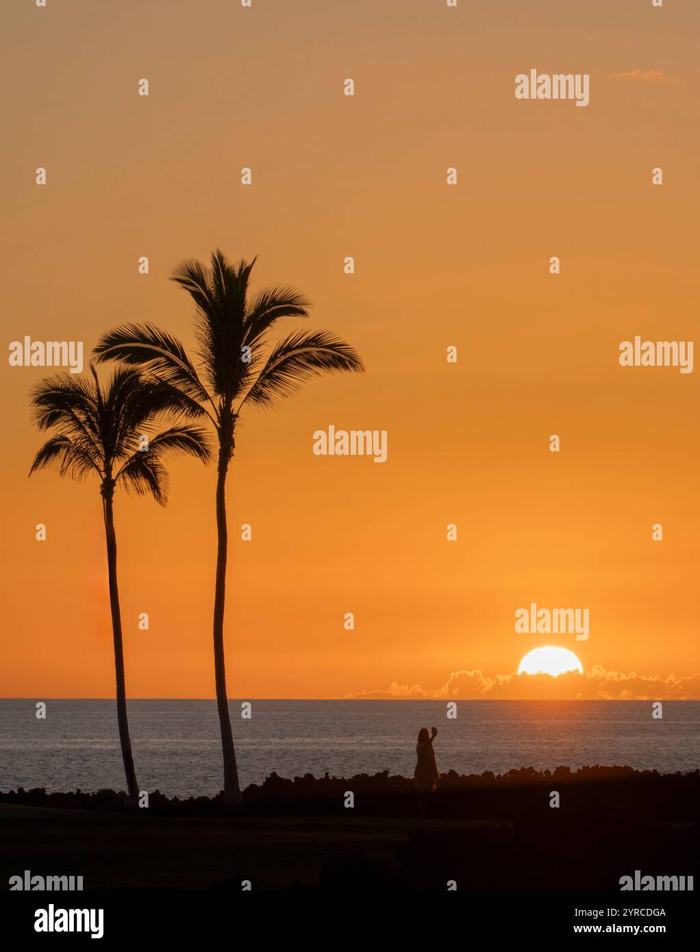 Dame avec appareil photo de téléphone portable prenant une photo du coucher du soleil. Hawaii, la Grande île, selfee Banque D'Images