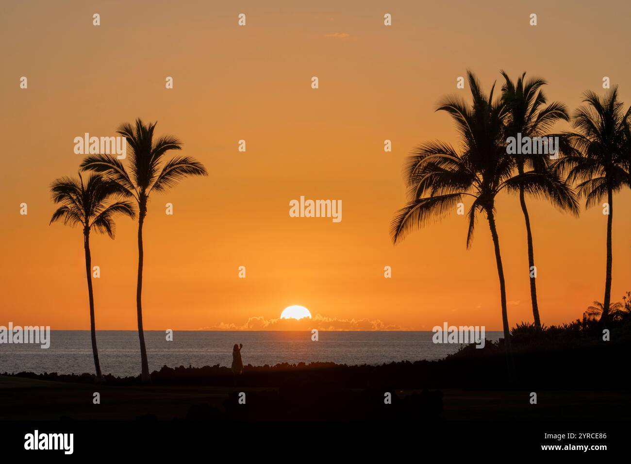 Dame avec appareil photo de téléphone portable prenant une photo du coucher du soleil. Hawaii, la Grande île, selfee Banque D'Images