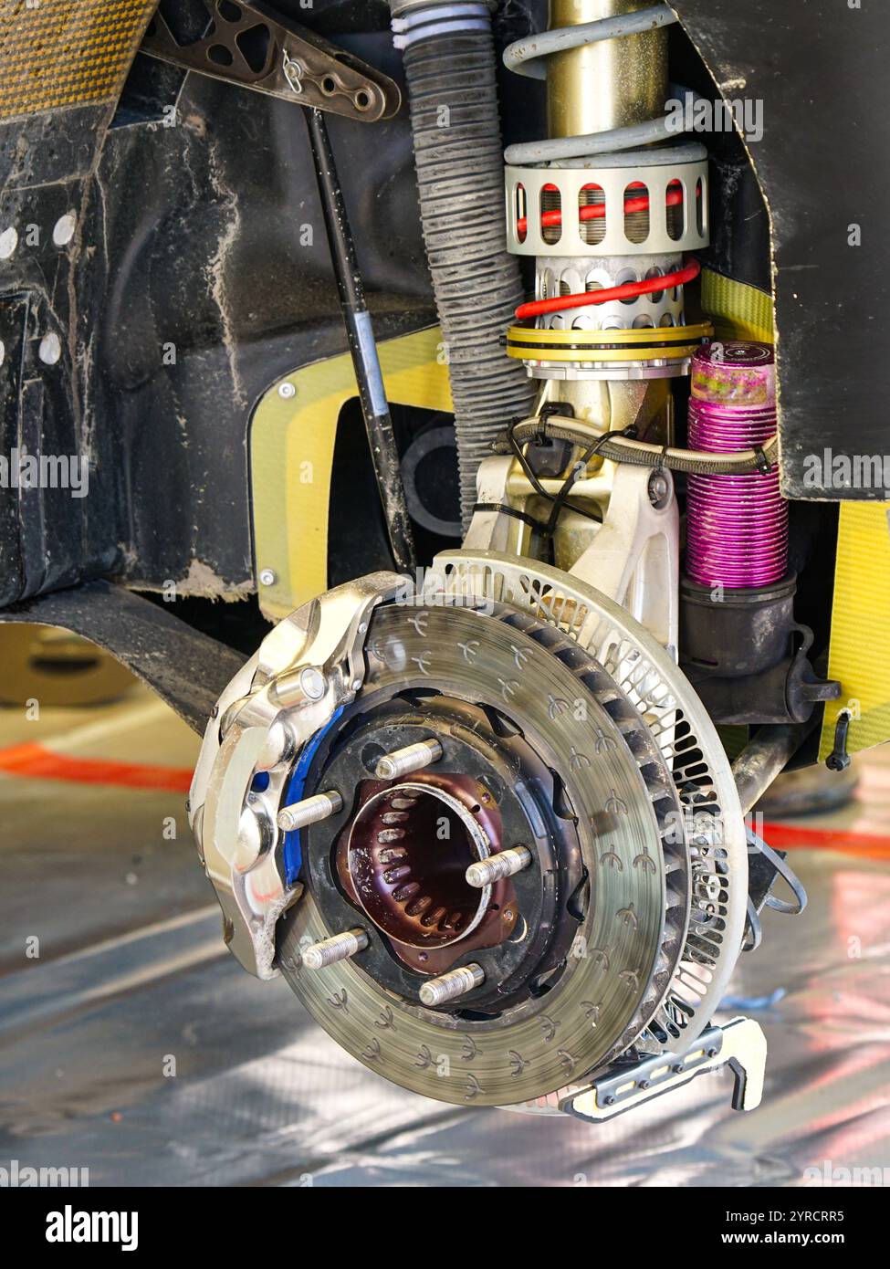 Entretien de voiture de rallye dans le parc de service, suspension haute performance de roue arrière et disque de frein avec étrier Banque D'Images