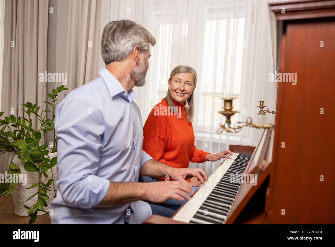 Femme mature ayant un cours de musique avec un professeur masculin Banque D'Images